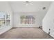 Spacious living area with neutral carpet, large window, and staircase access at 5531 Rosehill Rd # 204, Sarasota, FL 34233