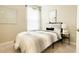This bedroom is decorated with neutral colors, modern furniture, and natural light from the window at 5684 Blue Reef Place, Nokomis, FL 34275