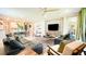 Open-concept living room featuring stylish sofas, a dining area, and a view of the kitchen at 5684 Blue Reef Place, Nokomis, FL 34275