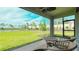 Screened patio overlooking a well-maintained lawn and pond providing a serene outdoor space at 5684 Blue Reef Place, Nokomis, FL 34275