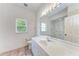 Bright bathroom featuring a vanity, toilet, and large mirror at 585 Khyber Ln, Venice, FL 34293