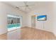 This bright bedroom boasts wood floors, a ceiling fan, and sliding glass doors with a view of the pool at 585 Khyber Ln, Venice, FL 34293