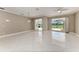 Spacious living room with white tile floors, neutral walls, and sliding glass doors to the lanai at 585 Khyber Ln, Venice, FL 34293