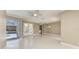 Expansive living space with white tile floors, glass doors to the pool, and decorative lighting at 585 Khyber Ln, Venice, FL 34293