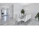 An open, airy dining space is highlighted by marble floors and a modern chandelier, adjacent to the foyer at 6203 Grandview Hill Ct, Bradenton, FL 34203