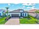 Charming single-Gathering home featuring a tile roof, manicured lawn and a paver driveway leading to a two-car garage at 6203 Grandview Hill Ct, Bradenton, FL 34203