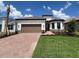 Beautiful single-story home featuring a brick-paved driveway, a brown two-car garage door, and well-manicured landscaping at 6203 Grandview Hill Ct, Bradenton, FL 34203
