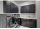 Well-equipped laundry room with dark cabinets, modern washer and dryer, and plenty of storage and counter space at 6203 Grandview Hill Ct, Bradenton, FL 34203
