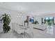 Bright, open-plan living and dining area featuring marble floors, contemporary lighting, and stylish white furniture at 6203 Grandview Hill Ct, Bradenton, FL 34203