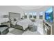 Serene main bedroom with lake views from large windows, tray ceiling and neutral decor at 6203 Grandview Hill Ct, Bradenton, FL 34203