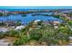 A serene aerial view shows the property amidst lush greenery and a scenic waterfront at 6343 Hollywood Blvd, Sarasota, FL 34231