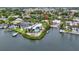 A waterfront property with a dock, surrounded by lush greenery, is showcased in this aerial view at 6343 Hollywood Blvd, Sarasota, FL 34231