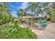 Spacious backyard with lush tropical landscaping, hammock, pond, and a covered lanai for relaxation at 6343 Hollywood Blvd, Sarasota, FL 34231