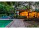 Backyard pool with a covered patio, grill, luscious landscaping, and a walkway to the home at 6343 Hollywood Blvd, Sarasota, FL 34231