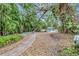 Lush backyard featuring a brick path leading to a refreshing pool, surrounded by tropical foliage at 6343 Hollywood Blvd, Sarasota, FL 34231