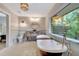 This bathroom features a clawfoot tub, a vanity mirror, and a view to the exterior at 6343 Hollywood Blvd, Sarasota, FL 34231