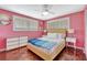 Bright bedroom featuring hardwood floors, a ceiling fan, and two windows with matching nightstands at 6343 Hollywood Blvd, Sarasota, FL 34231