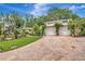 Charming home exterior with a brick driveway, lush lawn, and a well-manicured garden at 6343 Hollywood Blvd, Sarasota, FL 34231