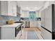 Bright kitchen with white cabinetry, stainless appliances, light countertops, and a decorative backsplash at 6343 Hollywood Blvd, Sarasota, FL 34231