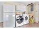 Functional laundry room featuring a refrigerator, modern washer, dryer, and utility sink for convenience at 6343 Hollywood Blvd, Sarasota, FL 34231