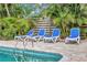 A beautiful pool area featuring lounge chairs on a brick patio surrounded by lush tropical foliage at 6343 Hollywood Blvd, Sarasota, FL 34231