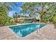 Inviting in-ground pool surrounded by a brick patio and lush tropical landscaping at 6343 Hollywood Blvd, Sarasota, FL 34231