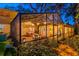 Enclosed sunroom featuring a dining area, seating, a hanging chair, and a view of the tropical backyard at 6343 Hollywood Blvd, Sarasota, FL 34231