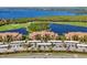 Stunning aerial view of condos with a golf course, a lake, covered parking and beautiful landscaping at 6509 Grand Estuary Trl # 203, Bradenton, FL 34212