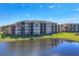 Aerial view of multi-story buildings and a pond surrounded by green lawns at 6509 Grand Estuary Trl # 203, Bradenton, FL 34212