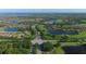Stunning aerial view showcasing the community's lush green golf course, mature trees, and elegant homes near the water at 6509 Grand Estuary Trl # 203, Bradenton, FL 34212