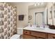 Well-lit bathroom featuring a shower with patterned curtain and storage at 6509 Grand Estuary Trl # 203, Bradenton, FL 34212