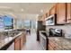 Charming kitchen featuring granite countertops, stainless appliances, and a view into the dining area at 6509 Grand Estuary Trl # 203, Bradenton, FL 34212