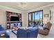 Relaxing living room featuring comfortable furniture, a large TV, and sliding doors to a private balcony at 6509 Grand Estuary Trl # 203, Bradenton, FL 34212