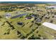 Captivating aerial perspective revealing peaceful ponds, verdant trees, and a horse arena ideal for an exclusive escape at 6605 253Rd St E, Myakka City, FL 34251