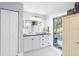 Bathroom features white cabinets, black countertop, and a door to the pool area at 6605 253Rd St E, Myakka City, FL 34251