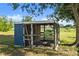 A spacious chicken coop is nestled under a tree, with a mix of solid and wire-mesh walls at 6605 253Rd St E, Myakka City, FL 34251