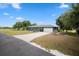 Beautiful blue home featuring an attached two-car garage, a well-manicured lawn, and a concrete driveway at 6605 253Rd St E, Myakka City, FL 34251