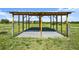 Well-constructed horse shelter with sturdy wooden beams, offering shade and shelter in a green pasture at 6605 253Rd St E, Myakka City, FL 34251