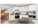 White kitchen with stainless steel appliances, subway tile backsplash, black countertops, and wood-look tile floors at 6605 253Rd St E, Myakka City, FL 34251
