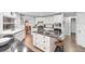 Bright kitchen featuring white cabinetry, stainless steel appliances, a functional island, and hardwood floors at 6605 253Rd St E, Myakka City, FL 34251