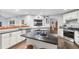 Well-lit kitchen featuring white cabinets, subway tile backsplash, stainless steel appliances, and an island with seating at 6605 253Rd St E, Myakka City, FL 34251