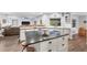 Open concept kitchen with a center island, white cabinets, dark countertops, and wood-look tile flooring at 6605 253Rd St E, Myakka City, FL 34251