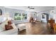 Spacious living room showcasing hardwood floors, comfortable seating, and ample natural light from large windows at 6605 253Rd St E, Myakka City, FL 34251
