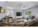 Living room with wood-look tile floors, a ceiling fan, a comfortable leather couch, and a view of the pool at 6605 253Rd St E, Myakka City, FL 34251