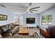 Living room features a ceiling fan, comfortable leather seating, a tv, and a view of the swimming pool at 6605 253Rd St E, Myakka City, FL 34251