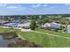 A beautiful aerial view of a luxurious home with a pool and solar panels in a lush, green community at 6702 Drewrys Blf, Bradenton, FL 34203