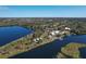An aerial view showcases lakefront cottages, surrounding forests, and nearby city amenities at 6702 Drewrys Blf, Bradenton, FL 34203