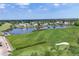 Aerial view featuring the golf course, putting green and peaceful lake with fountain at 6702 Drewrys Blf, Bradenton, FL 34203