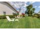 Lush backyard featuring well-maintained landscaping, outdoor seating, and a view of the adjacent lake at 6702 Drewrys Blf, Bradenton, FL 34203