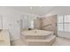 Bathroom showcasing a sunken tub, neutral tile, walk-in shower, and ample space at 6702 Drewrys Blf, Bradenton, FL 34203